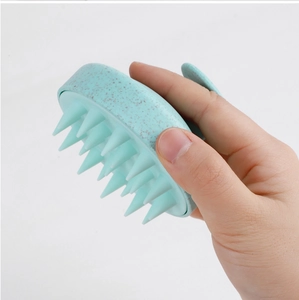 Macro view of mint green silicone hair brush with ring handle and massage bristles