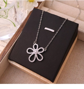 Detailed view of silver flower pendant with glittering zircons on a luxury chain