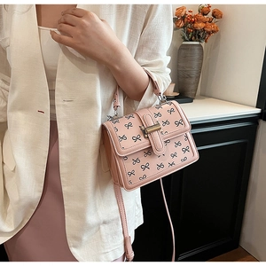 Borsa a tracolla rosa con motivi a fiocco nero e chiusura in metallo su modella