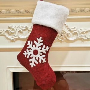 Vue détaillée d'une chaussette de Noël rouge avec flocon sur une cheminée blanche
