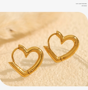 Macro view of gold heart-shaped hollow earrings with polished metallic finish
