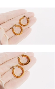 Detailed macro view of textured golden snake bone pattern on high-quality circular earrings