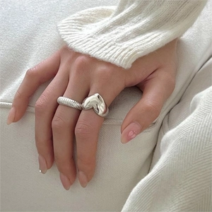 Set of two 925 sterling silver rings with heart charm and textured band on finger