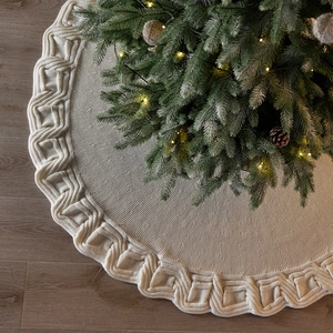 Classic beige knitted Christmas tree skirt with textured pattern on dark wood floor