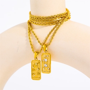 Detail of 18K gold tarot necklaces with The Moon and Carpe Diem engraved pendants