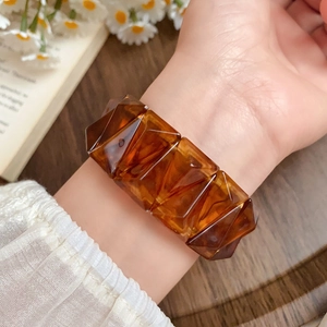 Close-up of geometric amber acrylic bracelet with faceted texture and retro style
