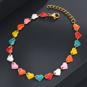 Close-up of gold chain bracelet with colorful enamel heart charms and lobster clasp