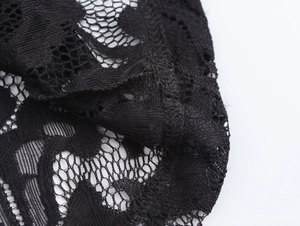 Detailed macro view of black lace fabric with intricate floral patterns and hollow texture