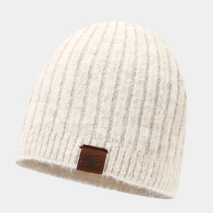 Detail of winter knit beanie with soft ribbed texture and snowflake leather patch