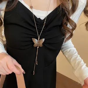 Collier artisanal avec pendentif papillon en bois et perles sur corde tressée brune
