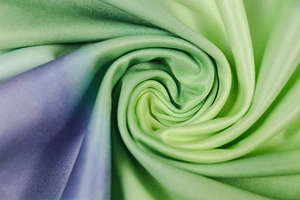 Close-up of green and purple gradient knit fabric with soft pleated texture on the dress