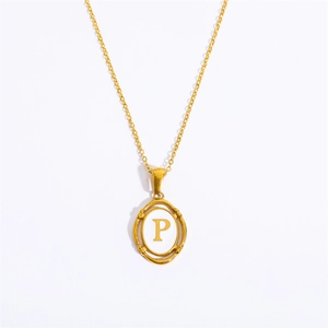 Detailed view of an oval gold pendant necklace featuring an engraved letter P on white inlay