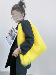 Close-up of yellow faux fur tote bag with long plush texture worn on shoulder
