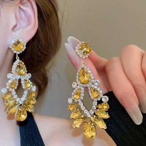 Macro shot of tiered amber crystal drop earrings with sparkling rhinestones in silver settings