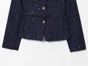 Detail der dunkelblauen Tweed-Jacke mit glänzenden Pailletten und goldenen Knöpfen