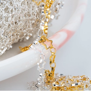 14k gold and silver hollow star chains for DIY jewelry making on a marble plate