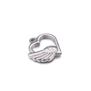 Close-up of heart-shaped winged pendant with intricate swirl patterns in silver metal