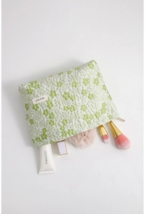 Detail view of floral embroidered makeup bag with spacious interior and zipper closure