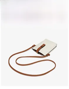 Detail of genuine leather phone bag with lychee texture and brown strap knots