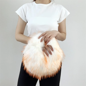 Detail of white and orange faux fur hand warmer bag showing soft texture and round shape