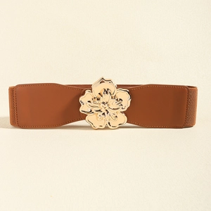 Détail de la ceinture élastique marron avec une boucle florale en métal doré brillant