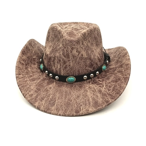 Detail of vintage brown suede cowboy hat with turquoise gemstones and leather band