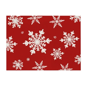 Detailed view of the woven fabric texture and festive white snowflake print on a red placemat