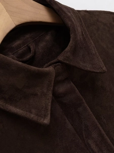 Detail shot of a dark brown suede shirt collar on a wooden hanger with texture view