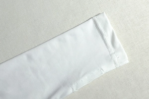 Detail of white long sleeve cuff showing precision stitching and fine fabric texture