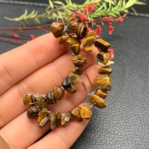 Detailed shot of handmade crescent hair clip with tiger eye stones and wire wrapping