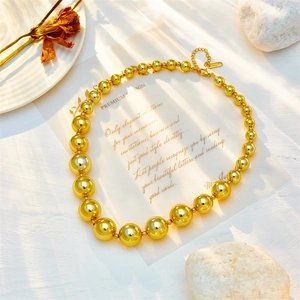Elegant gold layered bead necklace with S925 clasp on minimalist aesthetic background