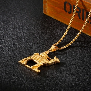 Macro shot of 18K gold-plated camel pendant on a twisted chain over a dark surface