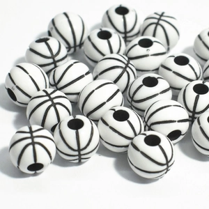 Vue macro de 50 perles en acrylique en forme de basket-ball noir et blanc avec trous percés