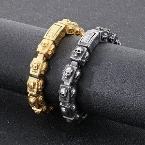 Detail of vintage skull bracelet in gold and silver finish with industrial punk reliefs