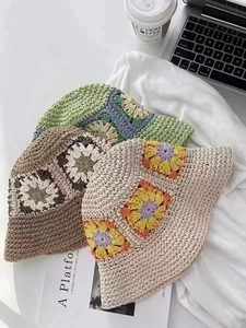 Detailed view of handmade crochet flower straw hats in beige, brown and green colors