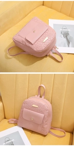 Detail of pink embossed flower mini backpack with gold twist lock on yellow velvet sofa