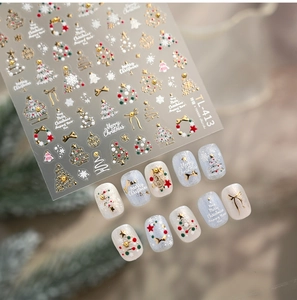 Detail of Christmas nail stickers featuring embossed gold trees and festive bells