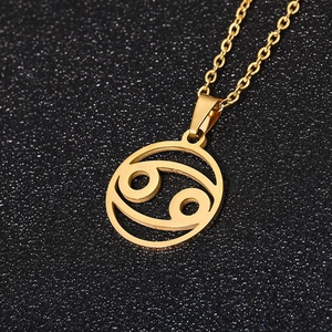 Collana segno zodiacale Cancro dorata con pendente traforato su uno sfondo nero stellato