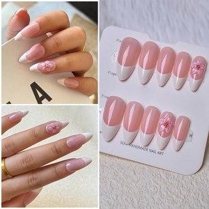Detail of almond-shaped French press-on nails with 3D pink floral relief decoration