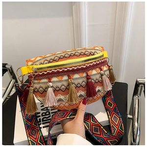 Close-up of bohemian woven chest bag featuring colorful tassels and geometric strap