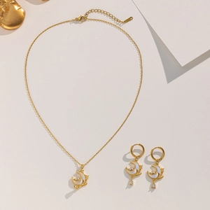 Detailed view of moon-shaped gold necklace and earrings with shell inlay and zircons