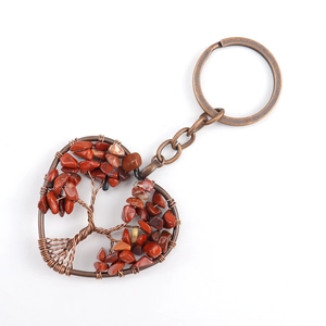 Close-up of heart-shaped tree of life keychain with bronze wire and red crystal stones
