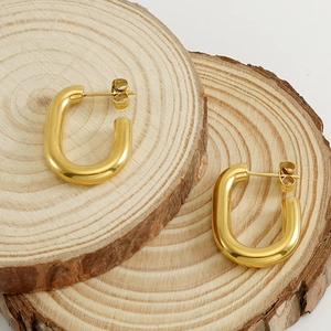 U-shaped 18k gold plated stainless steel earrings on minimalist wood display