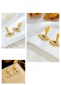 Macro view of gold plated evil eye hoop earrings with blue and white crystals