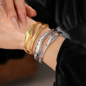 Irregular double-layer wavy cuff bracelet in polished gold and silver metal finishes