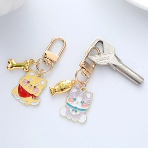 Detailed close-up of cartoon cat and dog metal keychains with enamel finish and lobster clasp