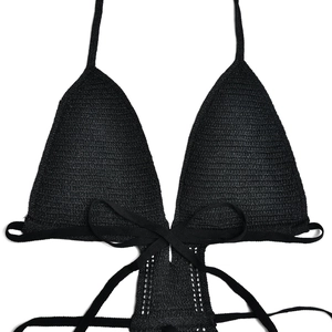 Close-up of black knitted halter dress with tie-up detail and textured fabric finish