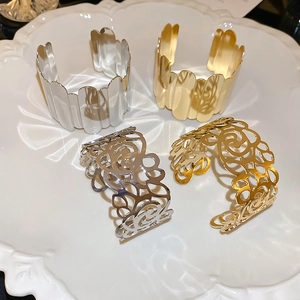 Detail view of gold and silver textured metal napkin rings with embossed patterns