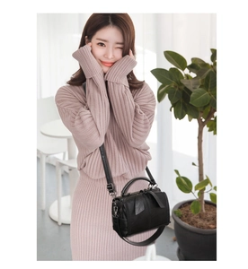 Detail of black PU leather Boston bag with adjustable strap and smooth zipper closure