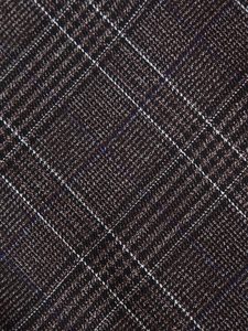 Gros plan sur la texture du tissu écossais sombre avec des motifs marron pour tailleur femme